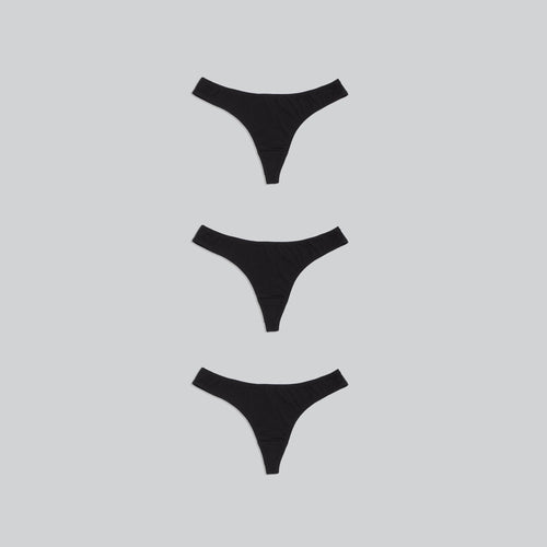 Pack of three organic cotton thongs in charcoal black color, wide waist band and ultra comfy on a grey background.